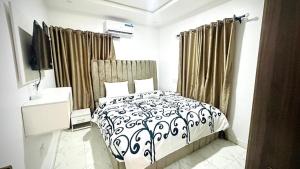 1 dormitorio con cama y cortinas en blanco y negro en Kunbiz Apartments, en Murtala Muhammed International Airport 4 fotos más