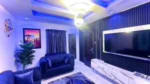 Una sala de estar con un sofá y un televisor de pantalla plana. en Kunbiz Apartments, en Murtala Muhammed International Airport