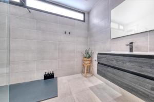 a bathroom with a sink and a mirror at Luxury White House Apartment in Puerto Calero +28 photos