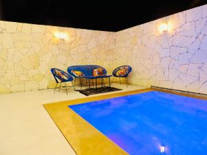 uma piscina com cadeiras e uma mesa num quarto em Modern villa with a private pool em Marraquexe