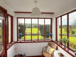 a room with windows with a view of a field at Kilpatrick Farm House in Pinmore