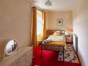 a small bedroom with a bed and a mirror at Kilpatrick Farm House in Pinmore