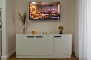 une armoire blanche avec une photo sur le mur dans l'établissement Planet Residence - Harmony Lux, à Niš