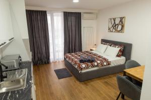 une chambre avec un lit et une cuisine avec une table dans l'établissement Planet Residence - Harmony Lux, à Niš 75 autres photos