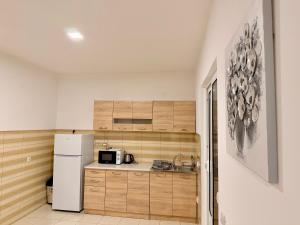 M apartment 3 في بار: مطبخ بخزائن خشبية وثلاجة بيضاء