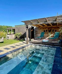 a swimming pool in a backyard with a pergola at La Clé des Champs - Studio PiscineSPA-Sauna au jardin tropical idyllique et bucolique in Jouarre