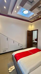 Comfort Deluxe inn في كيغالي: غرفة نوم بها سرير كبير وبطانية حمراء