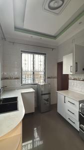 Comfort Deluxe inn في كيغالي: مطبخ كبير مع أجهزة بيضاء ونافذة