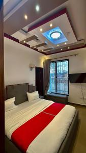 Comfort Deluxe inn في كيغالي: غرفة نوم بها سرير كبير وبطانية حمراء