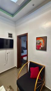 Comfort Deluxe inn في كيغالي: غرفة بها أريكة وتلفزيون وسرير