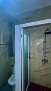 Comfort Deluxe inn في كيغالي: حمام فيه شطاف و مرحاض