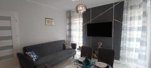 a living room with a couch and a table at Good Place Kodowa in Skorka