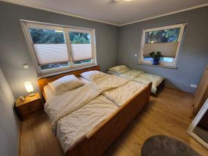 une chambre avec deux lits et deux fenêtres dans l'établissement Modern and idyllic apartment, à Jettingen-Scheppach