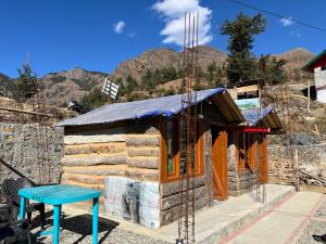 une maison en construction avec un tabouret bleu dans l'établissement Hill View Cottage, à Chakrata