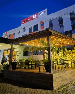 a restaurant with tables and chairs in front of a hotel at Transamerica Fit Catalão in Catalão