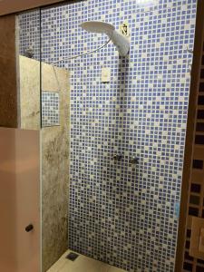 bagno con doccia e parete piastrellata blu di ACONCHEGANTE Quarto a Rio Verde