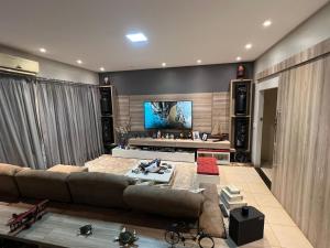 un soggiorno con un divano e una TV di ACONCHEGANTE Quarto a Rio Verde