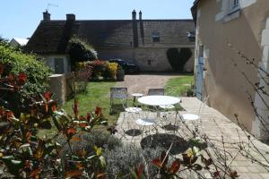 a patio with a table and chairs in a yard at À La Croisée Des Châteaux 3étoiles in Ouchamps