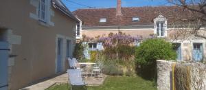 a small yard with chairs and a table in front of a house at À La Croisée Des Châteaux 3étoiles in Ouchamps +11 photos