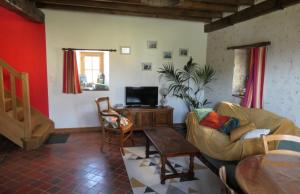 a living room with a couch and a table at À La Croisée Des Châteaux 3étoiles in Ouchamps