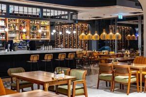 a restaurant with tables and chairs and a bar at Planet Residence - Harmony Lux & SPA in Niš