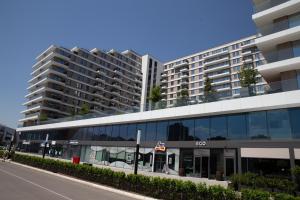 un bâtiment avec une station-service devant un grand bâtiment dans l'établissement Planet Residence - Harmony Lux, à Niš