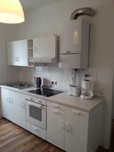 eine weiße Küche mit weißen Schränken und einer Spüle in der Unterkunft Lorenz Apartment in Hattingen + 14 Fotos