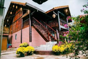 a house with a staircase and flowers in front of it at Sapung homestay Bảo Lộc in Blao Srê