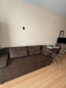 un salon avec un canapé marron et une table dans l'établissement Sunny day 5, à Tŭnkovo