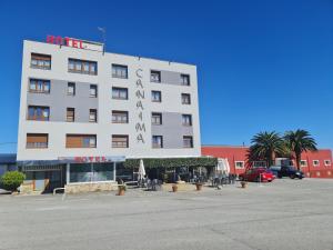 un hotel en un estacionamiento con un gran edificio en Hotel Canaima Bruma 1,5 k Camino, en O Mesón Do Vento 