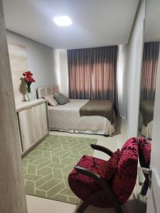 ein kleines Zimmer mit einem Bett und einem Stuhl in der Unterkunft Residencial Baviera in Navegantes + 40 Fotos