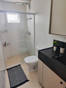ein Badezimmer mit Toilette und Glasdusche in der Unterkunft Residencial Baviera in Navegantes
