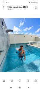 eine Person in einem Pool mit Springbrunnen in der Unterkunft Residencial Baviera in Navegantes