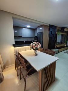 eine Küche mit einem Tisch mit einer Vase mit Blumen darauf in der Unterkunft Residencial Baviera in Navegantes