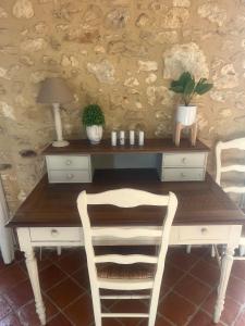 een bureau met 2 stoelen en een tafel met een lamp bij La Vigne in Pelissous +16 foto's