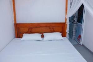 een bed met twee witte kussens in een slaapkamer bij Nadi Villa Midigama in Midigama East