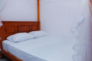 een bed met witte lakens en 2 kussens bij Nadi Villa Midigama in Midigama East +20 foto's