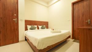 a bedroom with a large bed with white sheets at The Namami Tapovan in Rishīkesh