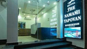 a lobby with a glass door with a sign on it at The Namami Tapovan in Rishīkesh +1 photo