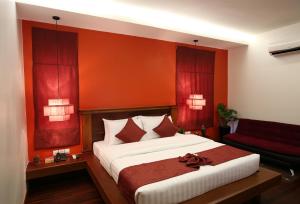 - une chambre avec un grand lit aux murs rouges dans l'établissement Holy Angkor Hotel, à Siem Reap