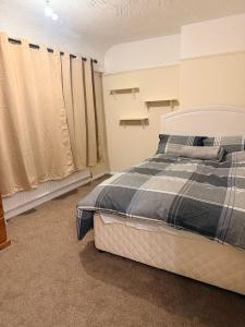 a bedroom with a bed with a blue and white blanket at Warn Cossy Luxe Room in Addington