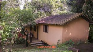 uma pequena casa no meio de uma floresta em Chale Rural em Nova Lima com Vista para o Jardim em Macacos