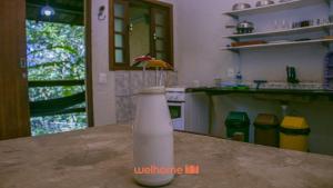 um vaso com flores sobre uma mesa na cozinha em Chale Rural em Nova Lima com Vista para o Jardim em Macacos mais 52 fotografias