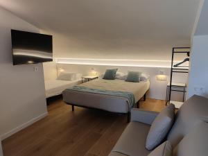 a small room with two beds and a couch at VuT QUINTA LA LEGUA in Quintanadueñas