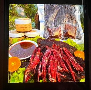 a table with a bunch of meat and other foods at Sapung homestay Bảo Lộc in Blao Srê