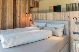 een groot wit bed met kussens erop bij Berggut Niggler - Pratum in Dobbiaco