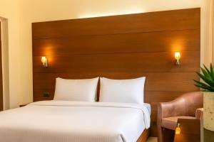 a bedroom with a large bed with a wooden headboard at Britannia Suites in Beirut