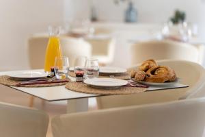 une table avec une assiette de pain et des verres de jus d'orange dans l'établissement Résidence Angers, à Angers 3 autres photos