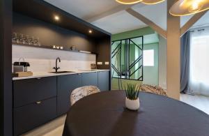 a kitchen with a black table and a sink at Maison avec espace bien-être privé in Mareuil-sur-Lay