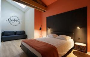 a bedroom with a large bed and a blue couch at Maison avec espace bien-être privé in Mareuil-sur-Lay